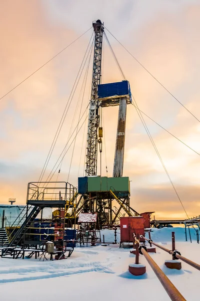 Drilling a deep well with a drilling rig in an oil and gas field. The field is located in the Far North beyond the Arctic Circle. Beautiful dramatic sky of the polar day.