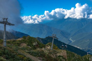 Dağlarda aşırı kablo araba sürmek. Dağlar yeşil eteklerinde. Yaz dinlenme.