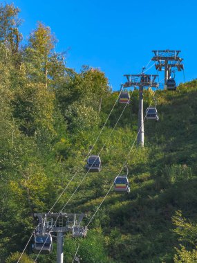 Dağlarda aşırı kablo araba sürmek. Dağlar yeşil eteklerinde. Yaz dinlenme.
