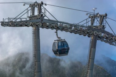 Dağlarda aşırı kablo araba sürmek. Dağlar yeşil eteklerinde. Yaz dinlenme.