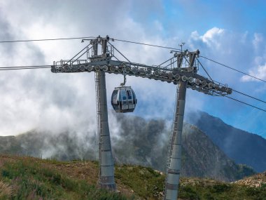 Dağlarda aşırı kablo araba sürmek. Dağlar yeşil eteklerinde. Yaz dinlenme.