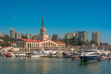 Yaz aylarında liman. Birçok farklı yat ve tekne yat limanında hazır. Yatçılar ve yolcuları denizde yelken açmaya hazırlanıyorlar. Sahil şehir bina arka planda.