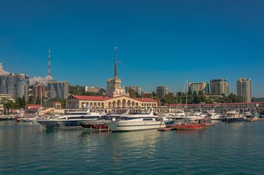 Yaz aylarında liman. Birçok farklı yat ve tekne yat limanında hazır. Yatçılar ve yolcuları denizde yelken açmaya hazırlanıyorlar. Sahil şehir bina arka planda.