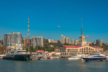Yaz aylarında liman. Birçok farklı yat ve tekne yat limanında hazır. Yatçılar ve yolcuları denizde yelken açmaya hazırlanıyorlar. Sahil şehir bina arka planda.