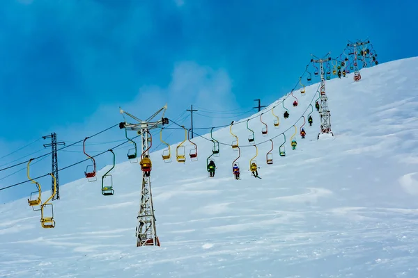 Extreme cable car ride. Winter holidays in the mountains. Snow-covered mountain slopes. Skiers and tourists.