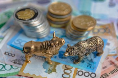 Bronz boğa ve ayı figürleri kağıt para ve metal sikke ile düzenlenmiştir. Arka plan bulanıklık. Borsa üzerinde ticaret sembolü ve kavramı.