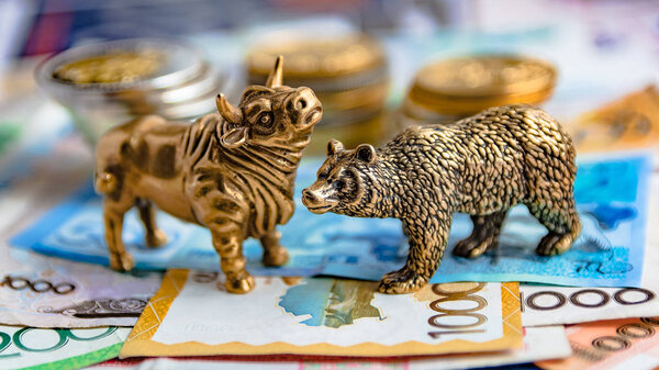 Бронзовые фигурки быков и медведей расставлены на бумажные деньги и металлические монеты. Фон размыт. Символ и концепция торгов на бирже
.