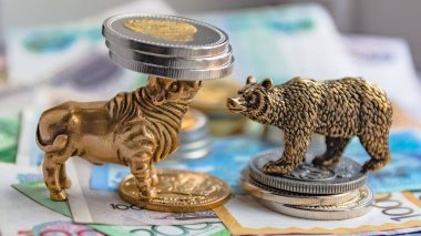 Bronz boğa ve ayı figürleri kağıt para ve metal sikke ile düzenlenmiştir. Arka plan bulanıklık. Borsa üzerinde ticaret sembolü ve kavramı.