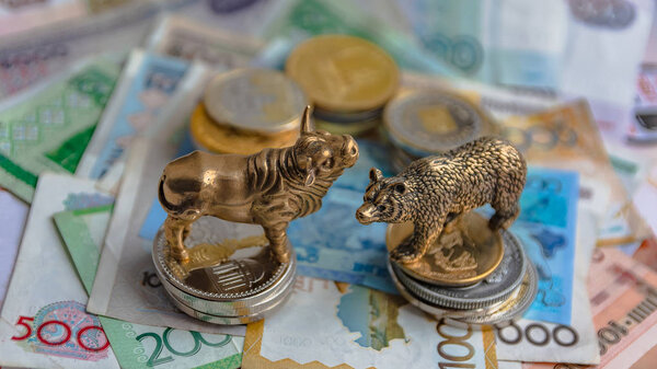 Бронзовые фигурки быков и медведей расставлены на бумажные деньги и металлические монеты. Фон размыт. Символ и концепция торгов на бирже
.