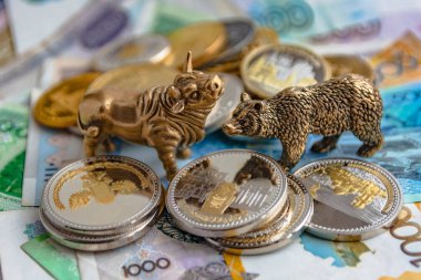 Bronz boğa ve ayı figürleri kağıt para ve metal sikke ile düzenlenmiştir. Arka plan bulanıklık. Borsa üzerinde ticaret sembolü ve kavramı.