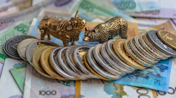 Бронзовые фигурки быков и медведей расставлены на бумажные деньги и металлические монеты. Фон размыт. Символ и концепция торгов на бирже
.