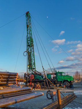 Alanda derin yağ kuyuları onarımı için Mobil teçhizat. Sondaj ve kasa boruları ön planda saklanır.