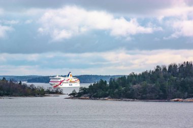 Stockholm / İsveç - 3 Mayıs 2019: Geminin güvertesinden İskandinav skerries ve fiyortların görünümü. Bulutlu bahar sabahı. Arka planda büyük bir feribot tekne Tallinn olduğunu.