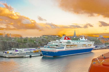 Stockholm / İsveç - 3 Mayıs 2019: Stockholm şehir manzarası ve liman da geminin güvertesinden görünüm. Iskelede büyük bir yolcu gemisi Olsen Cruise Line olduğunu. Arka planda güzel akşam gökyüzü.