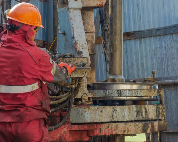 Werkboorder Rood Uniform Helm Bril Hij Gebruikt Een Hydraulische Moersleutel — Stockfoto