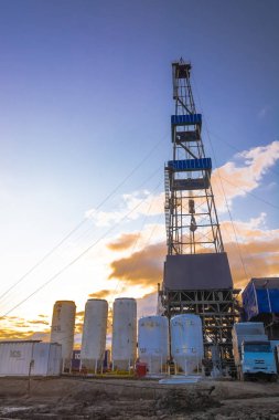 Kuleli sondaj kulesi. Alt katta sondaj ekipmanları var. Kuzey sahasında petrol ve gaz üretimi için derin bir kuyu açılan bölgede sondaj yapılıyor. Yaz kutup gecesi. Arkadan aydınlatmalı bulutlar ile güzel gökyüzü.