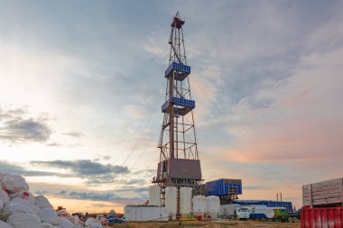 Kuleli sondaj kulesi. Alt katta sondaj ekipmanları var. Kuzey sahasında petrol ve gaz üretimi için derin bir kuyu açılan bölgede sondaj yapılıyor. Yaz kutup gecesi. Arkadan aydınlatmalı bulutlar ile güzel gökyüzü.