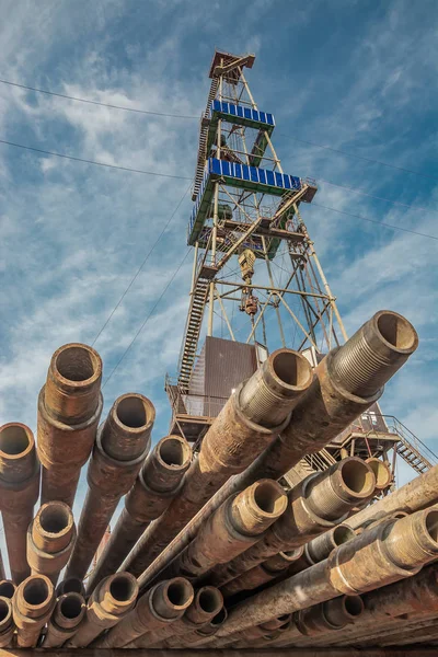 Petrol ve gaz çıkarma için kuzey sahasında sondaj kuyuları için sondaj kulesi. Ön planda matkap boruları vardır. Yaz günü. Mavi bulutlu gökyüzü.