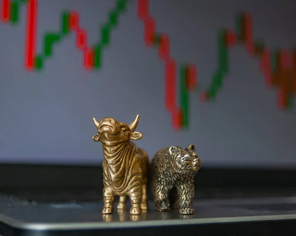 Bull and bear as symbols of stock trading on a blurred background of price graphics. The concept of symbolism of commodity and financial world markets.