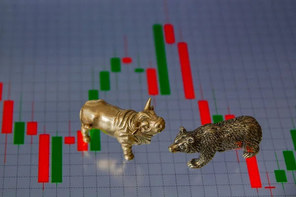 Bull and bear as symbols of stock trading on a blurred background of price graphics. The concept of symbolism of commodity and financial world markets.