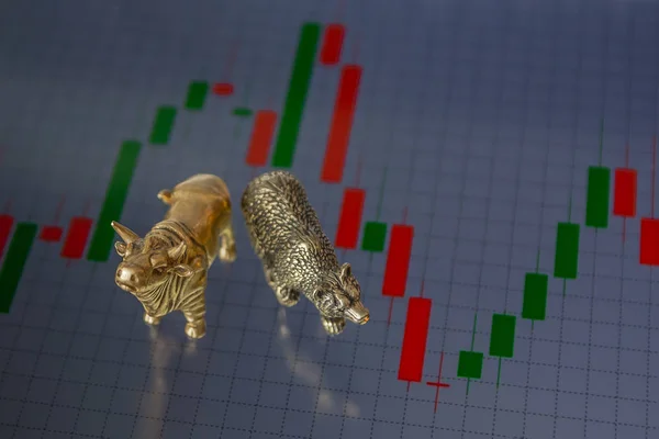 Bull and bear as symbols of stock trading on a blurred background of price graphics. The concept of symbolism of commodity and financial world markets.