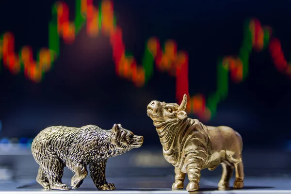 Bull and bear as symbols of stock trading on a blurred background of price graphics. The concept of symbolism of commodity and financial world markets.