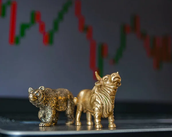 Bull and bear as symbols of stock trading on a blurred background of price graphics. The concept of symbolism of commodity and financial world markets.