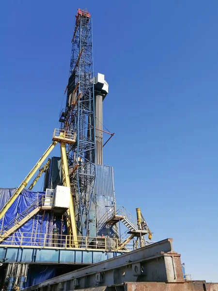 General view of the construction of a drilling rig for drilling oil and gas wells. Oil rig, equipment and communications. Drill pipes standing upright.