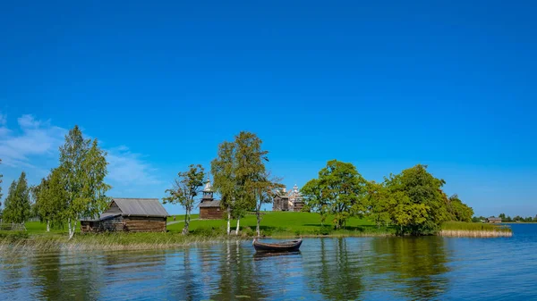 夏の晴れた日にオンガ湖のキジ島の風景 手前は漁船のある湖湾 背景には木造古建築の島の風景 — ストック写真