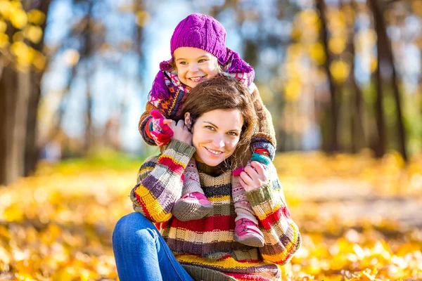 Mother and daughter playing in autumn park — Stock Photo, Image