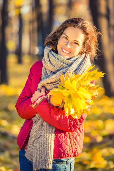 Šťastná mladá žena v podzimním parku — Stock fotografie