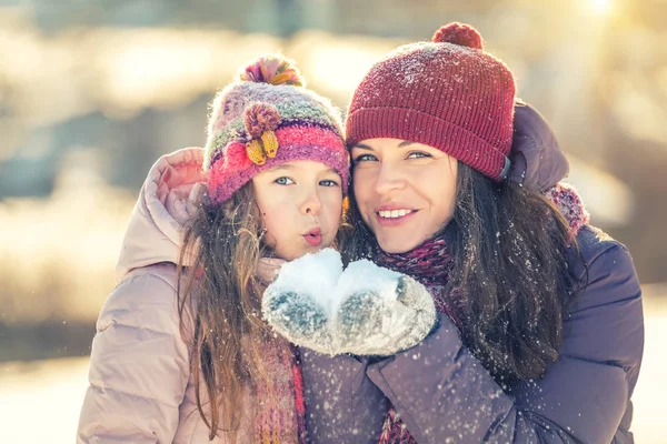 Mor och dotter leker i vinterparken — Stockfoto