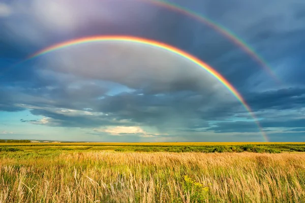 Arcobaleno sul cielo tempestoso in campagna durante il giorno d'estate — Foto Stock