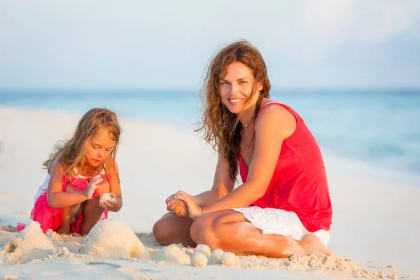 Мать и маленькая дочь играют на пляже на Мальдивах во время летних каникул — стоковое фото
