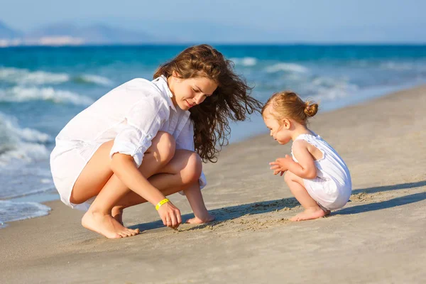 Mama și fiica se joacă pe plaja mării din Grecia — Fotografie, imagine de stoc