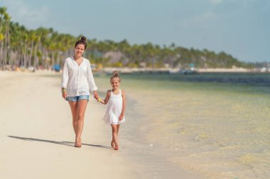 Young mother and little daughter enjoying the beach in Dominican Republic clipart