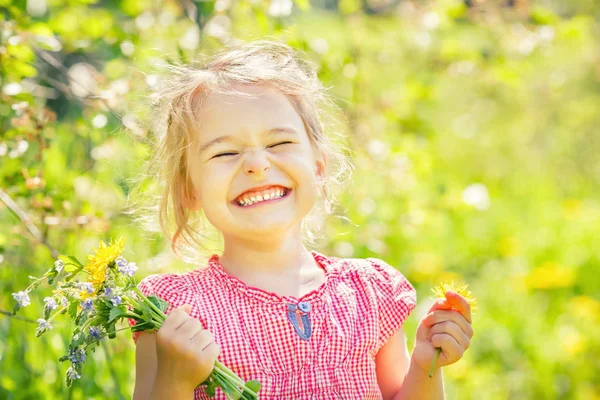 Gelukkig klein meisje in de lente zonnig park — Stockfoto