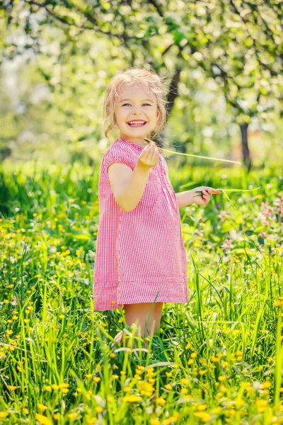 Šťastná holčička na jarní zahradě — Stock fotografie