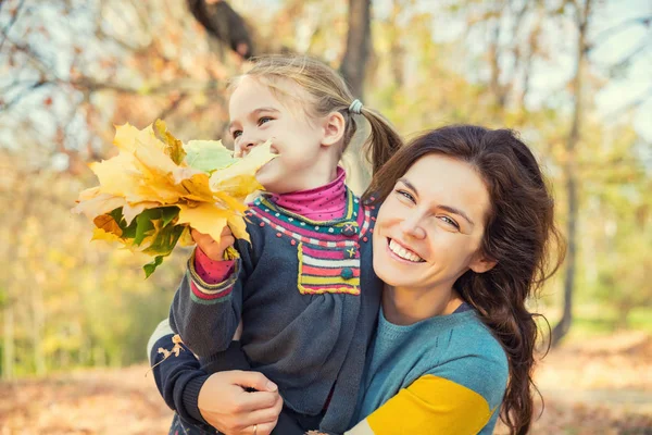 Mor och dotter njuter av soliga höst i parken — Stockfoto