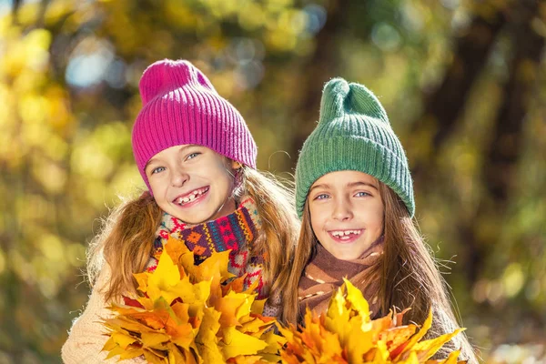 Dois sorrisos bonitos meninas de 8 anos posando juntas em um parque em um dia ensolarado de outono . — Fotografia de Stock