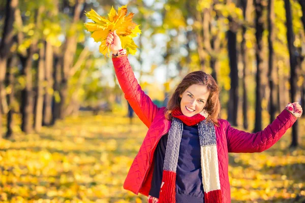 Gelukkige jonge vrouw in de herfst park — Stockfoto