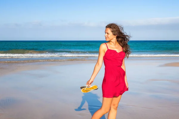 Giovane donna in abito rosso godendo la spiaggia — Foto Stock