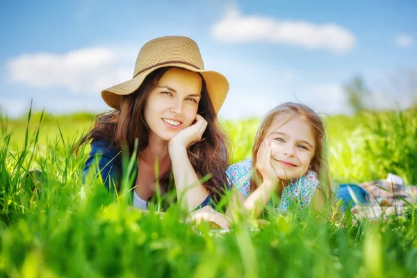 Madre e hija en el prado de primavera con hierba verde —  Fotos de Stock