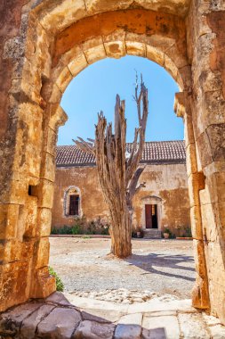 Kurutulmuş ağacın arkasında eski manastırın arch. Arkadi Manastırı - Crete, Yunanistan. 