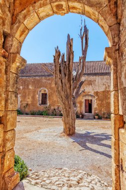 Kurutulmuş ağacın arkasında eski manastırın arch. Arkadi Manastırı - Crete, Yunanistan.