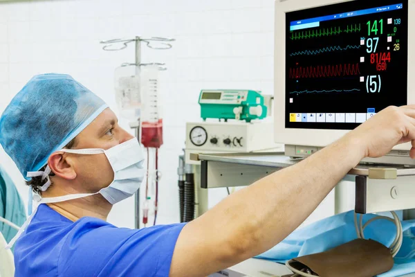 Doświadczony anestezjolog mężczyzna o monitor — Zdjęcie stockowe