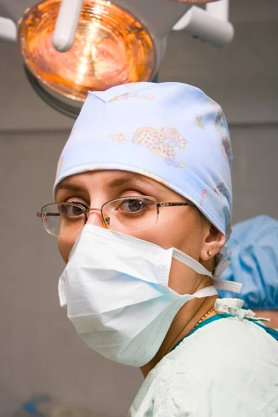 Jeune chirurgienne avec masque en salle d'opération Image En Vente