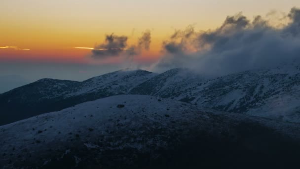 Colorido amanecer sobre montañas de invierno escondidas en las nubes — Vídeos de Stock