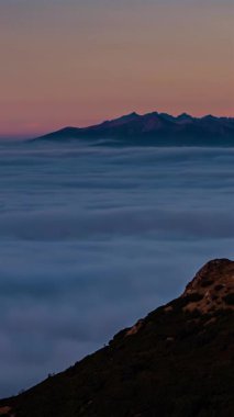 Şafak vakti alp dağları vadisinde yükselen sisli bulutların dikey zaman akışı. Sosyal medya için doğa, seyahat, yürüyüş ve turizm projeleri için mükemmel sisli manzara görüntüleri.