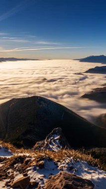 Altın gün batımında, bir dağ vadisinde hızla ilerleyen sisli bulutların dikey panoramik zaman atlaması. Göz kamaştırıcı sonbahar manzarası. Güneş yıldızı, sis ve manzaralı güneş ışınları. Doğa ve turizm için mükemmel.